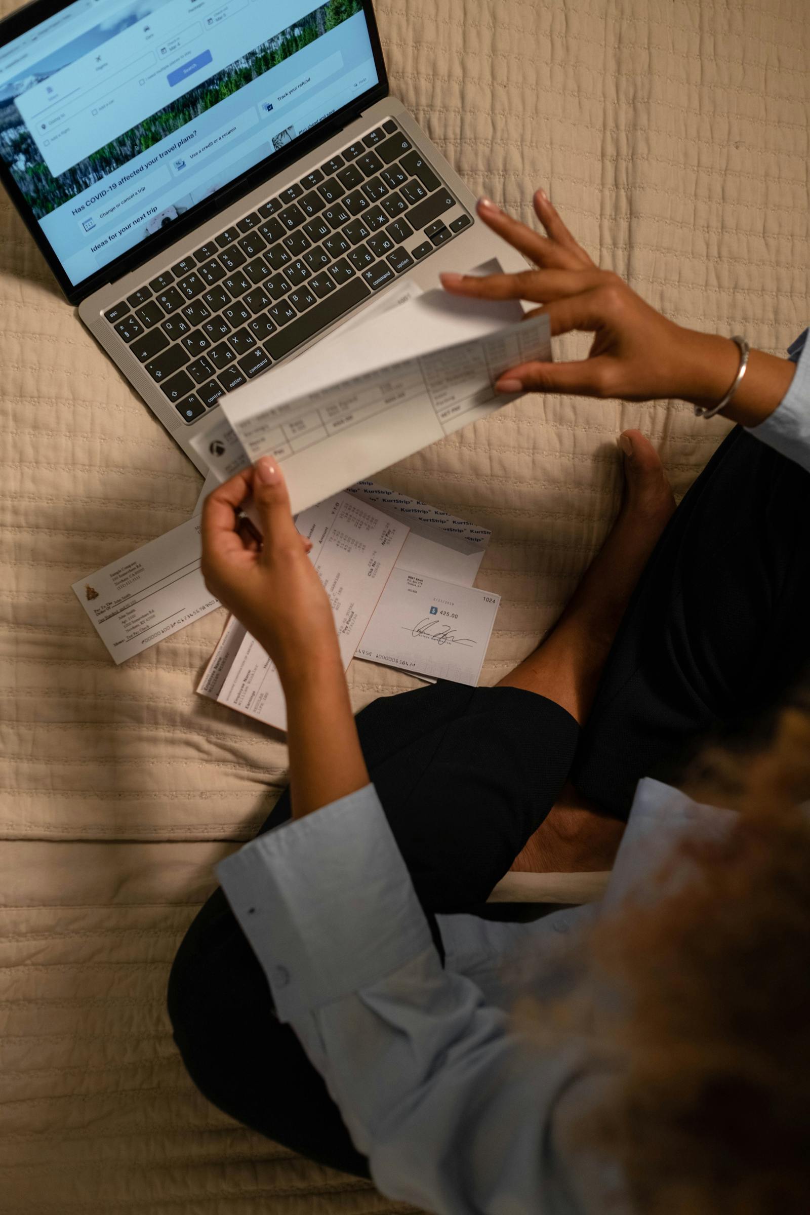 Managing finances with checks and a laptop