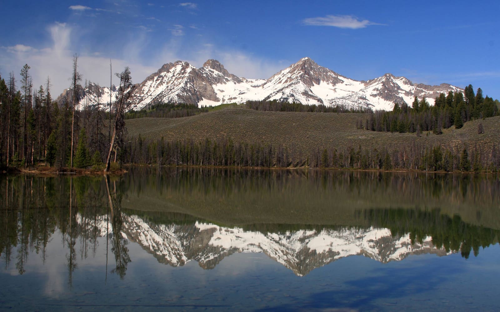 Snow-capped peaks of the Sawtooth Range reflected in the still water of Little Redfish Lake near Stanley, Idaho