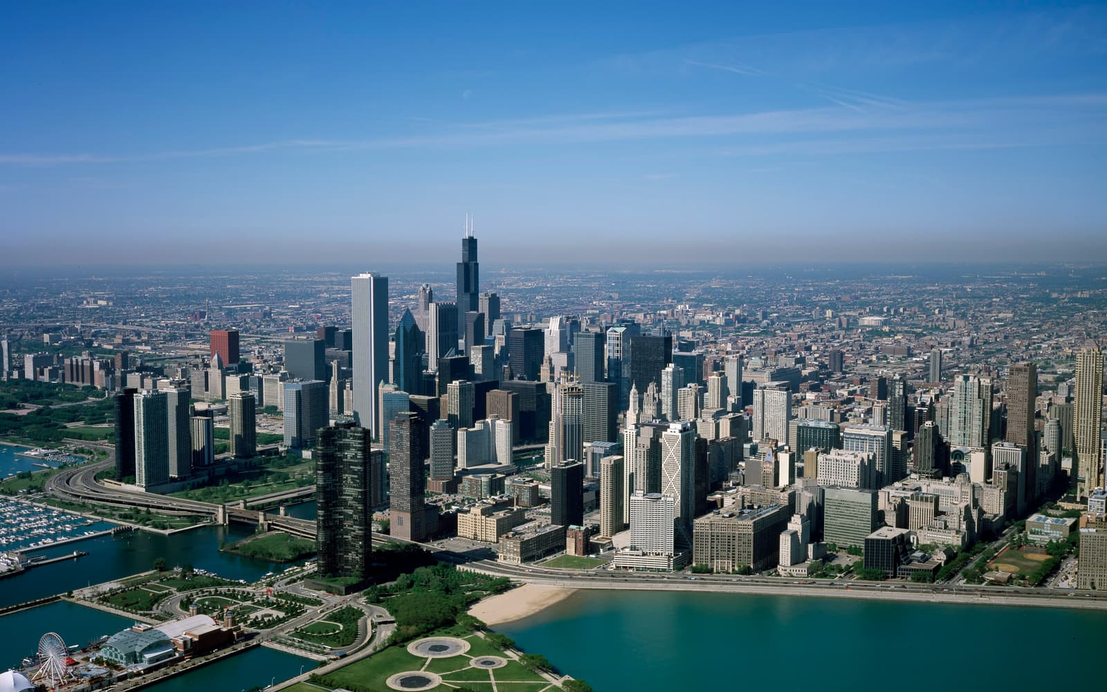 Aerial view of the downtown Chicago skyline, including the Willis Tower, along the Lake Michigan shoreline