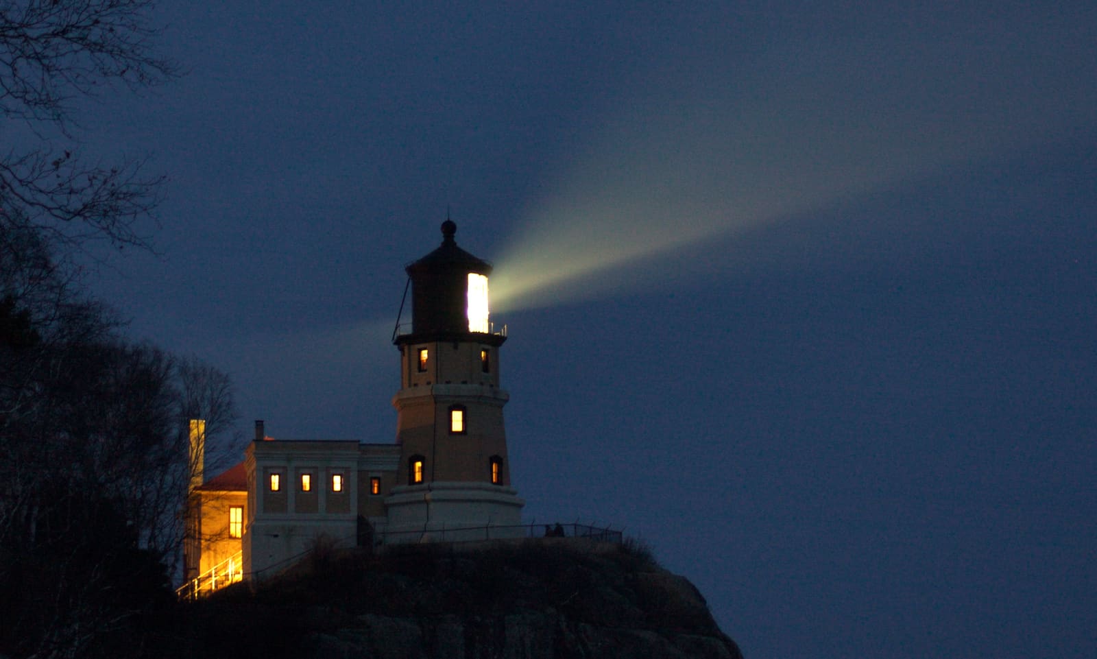 Split Rock Lighthouse on the North Shore of Lake Superior with its beacon lit at dusk