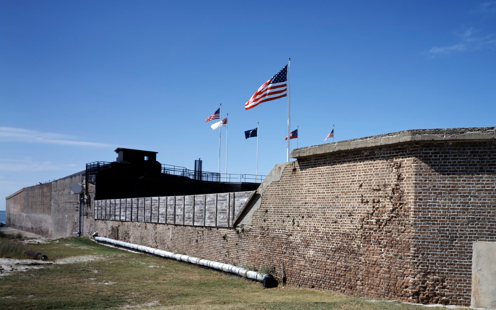 Brick walls of Fort Sumter with American and historic flags flying, Charleston Harbor, South Carolina