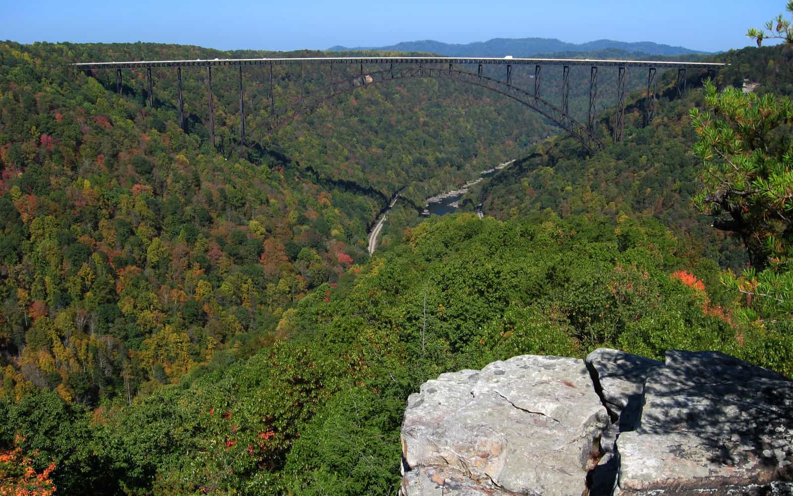 New River Gorge Bridge spanning the forested gorge with early fall color, seen from the Long Point overlook in West Virginia
